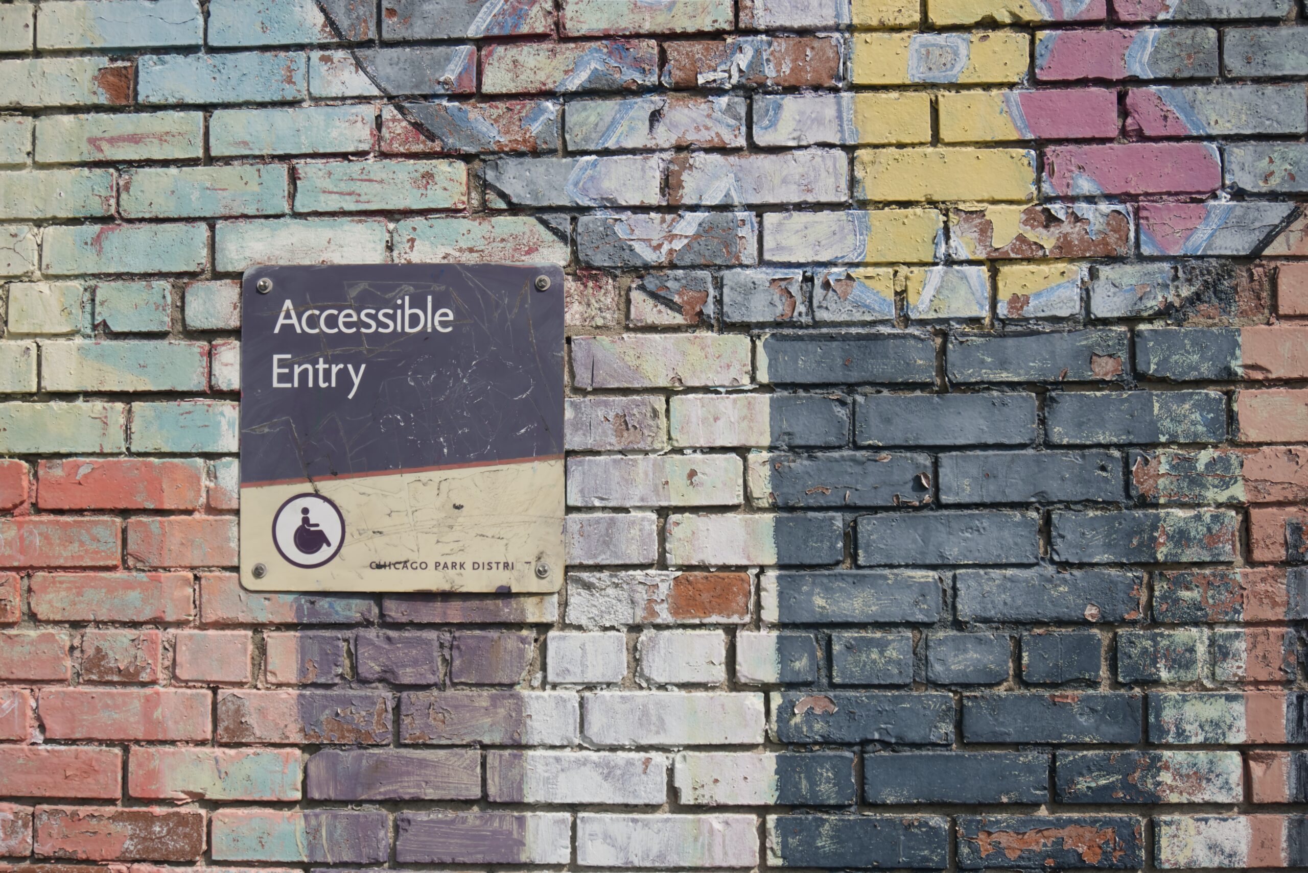 colourful brick wall with the sign 'accessible entry' on it